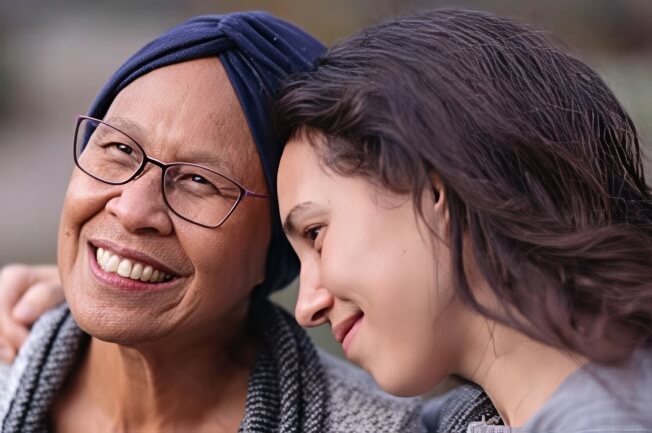 Woman comforting an older woman wearing a headscarf